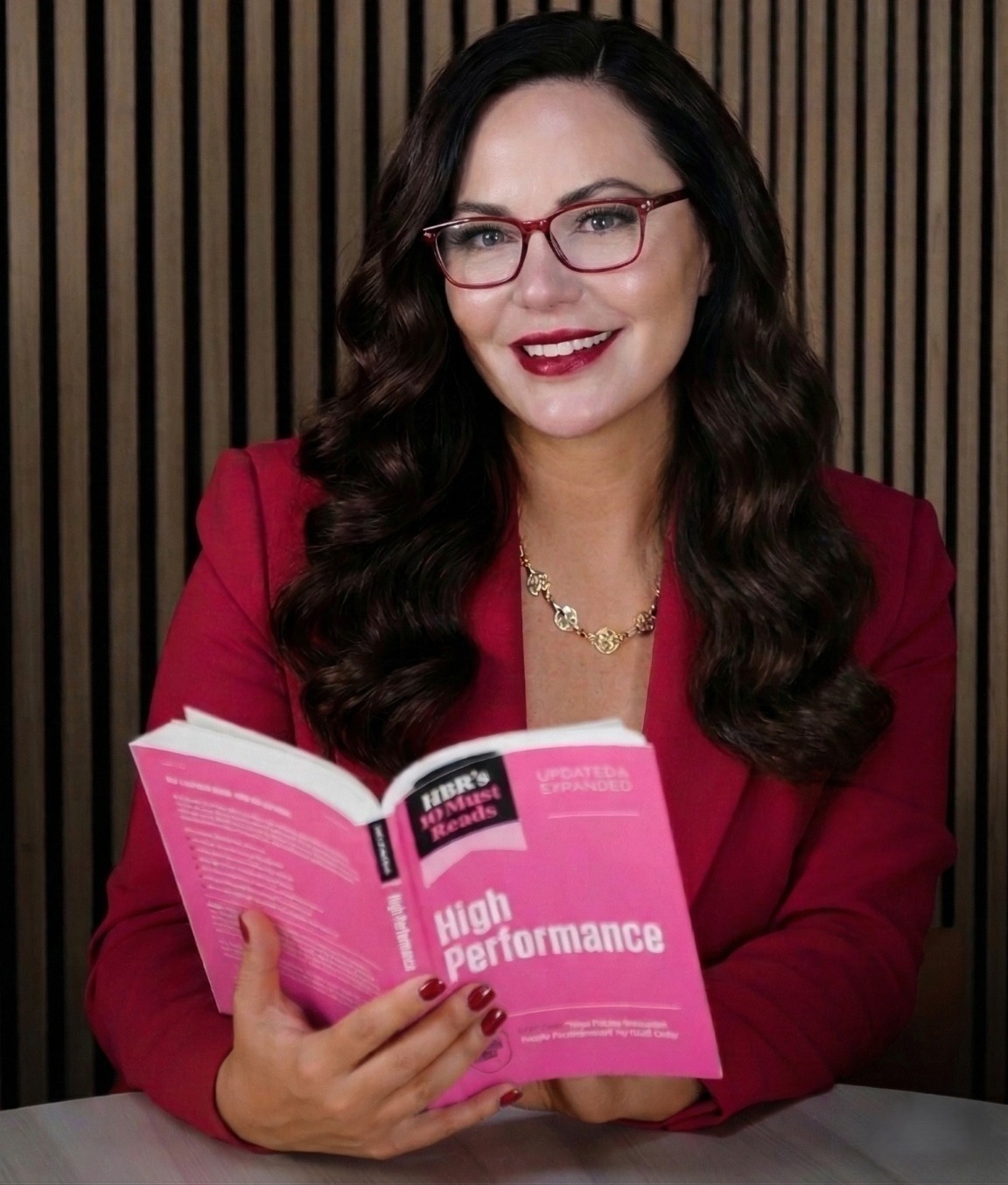 Stephanie Stasey holding an open book about high performance